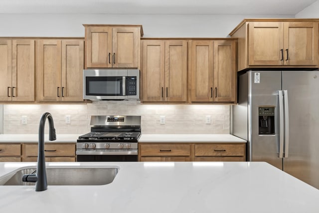 kitchen featuring sink, appliances with stainless steel finishes, and tasteful backsplash