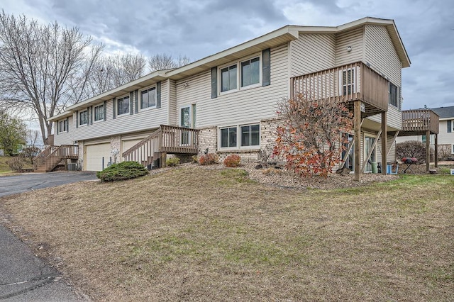 raised ranch featuring a garage and a front lawn