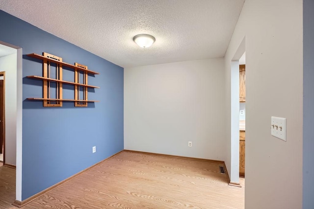 spare room with hardwood / wood-style flooring and a textured ceiling