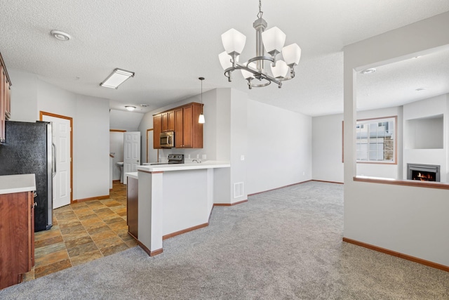 kitchen with hanging light fixtures, kitchen peninsula, appliances with stainless steel finishes, and dark colored carpet