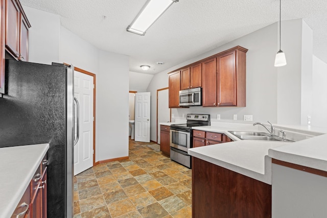 kitchen with a textured ceiling, appliances with stainless steel finishes, sink, hanging light fixtures, and kitchen peninsula