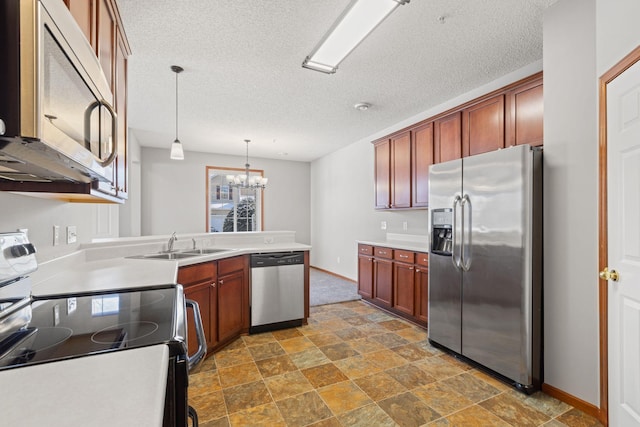 kitchen featuring a notable chandelier, a textured ceiling, hanging light fixtures, sink, and stainless steel appliances