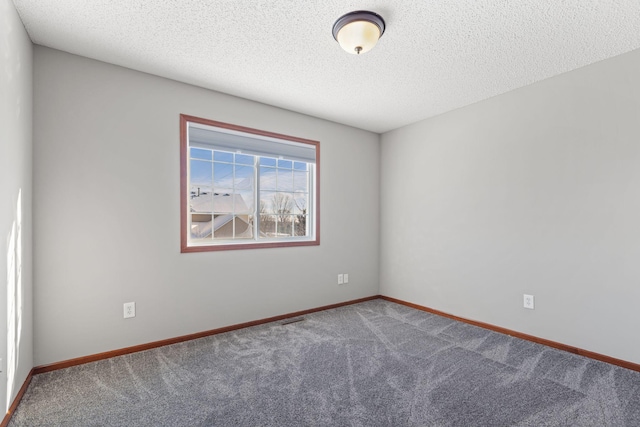 carpeted spare room with a textured ceiling