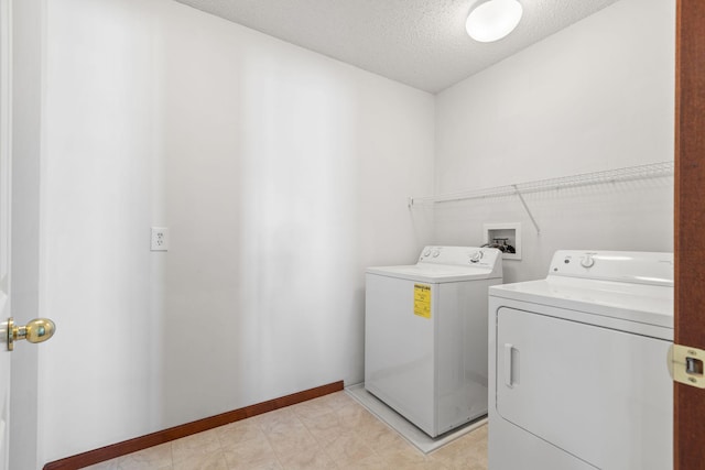 laundry room featuring a textured ceiling and washing machine and dryer