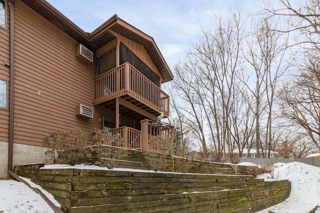 exterior space with an AC wall unit and a balcony