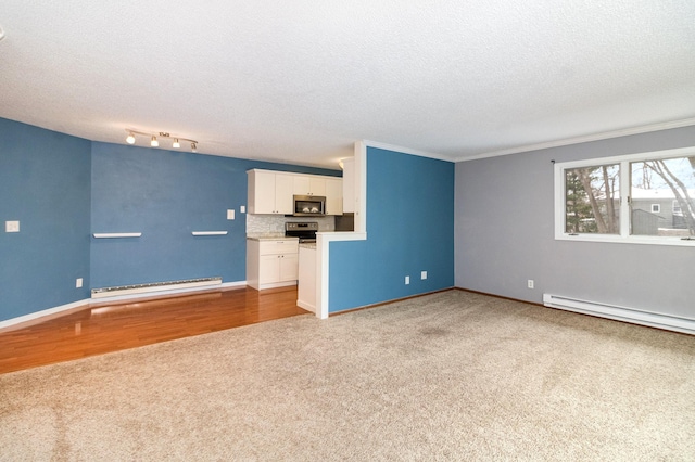 unfurnished living room featuring a baseboard heating unit, carpet floors, ornamental molding, and a textured ceiling