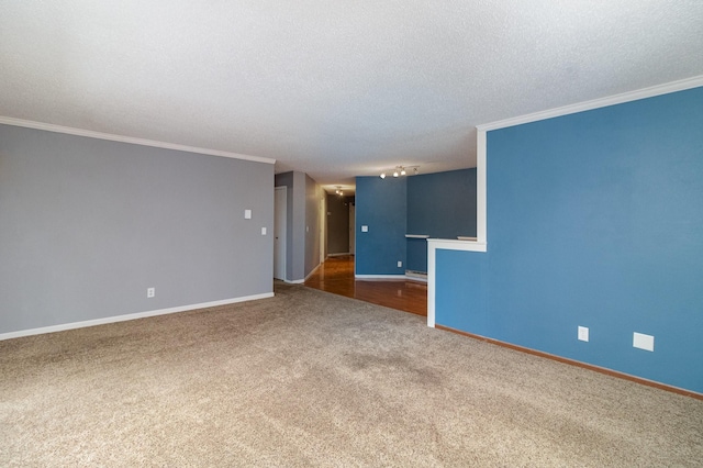 empty room featuring ornamental molding, a textured ceiling, and dark carpet