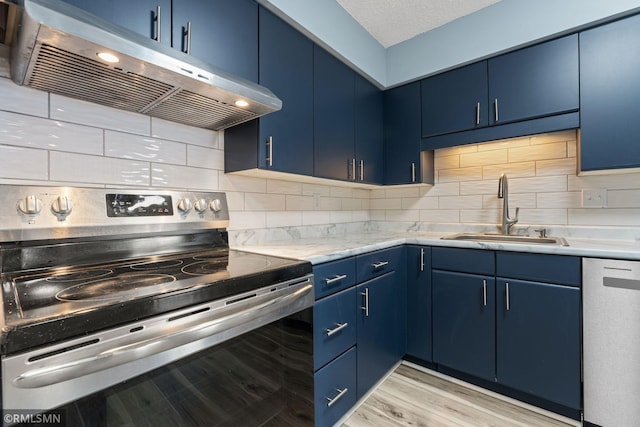 kitchen with tasteful backsplash, appliances with stainless steel finishes, blue cabinets, and sink