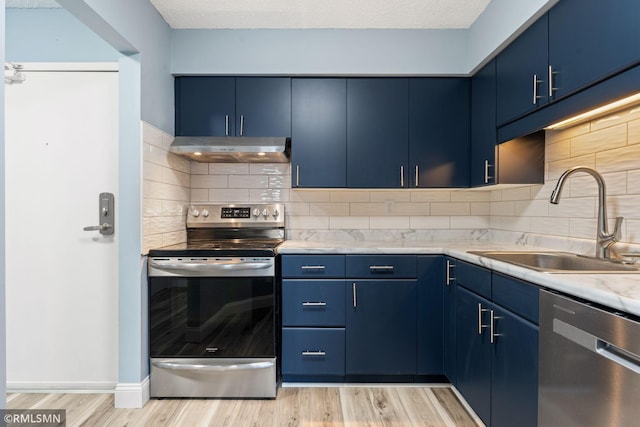 kitchen with sink, blue cabinetry, and appliances with stainless steel finishes