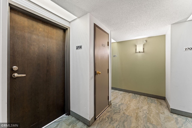 hall with light carpet and a textured ceiling