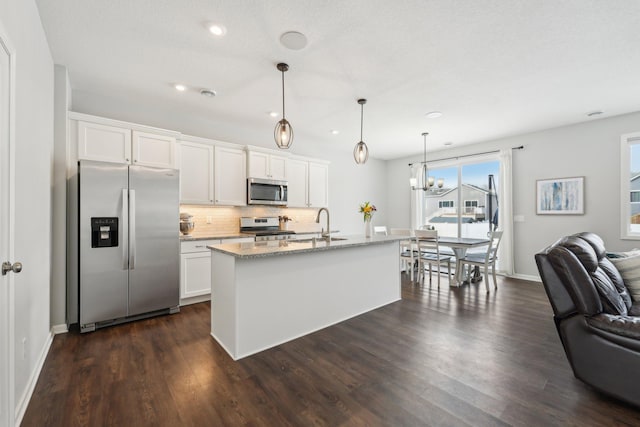 kitchen with white cabinets, a kitchen island with sink, and stainless steel appliances