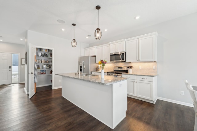 kitchen featuring white cabinetry, a center island with sink, stainless steel appliances, and hanging light fixtures