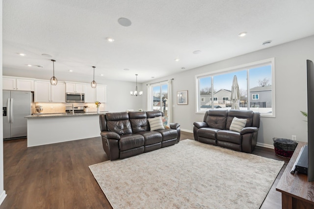 living room with a notable chandelier and dark hardwood / wood-style flooring