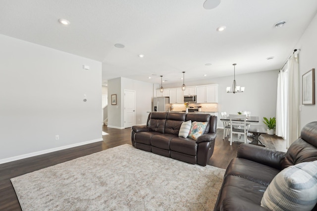 living room featuring a chandelier and dark hardwood / wood-style floors