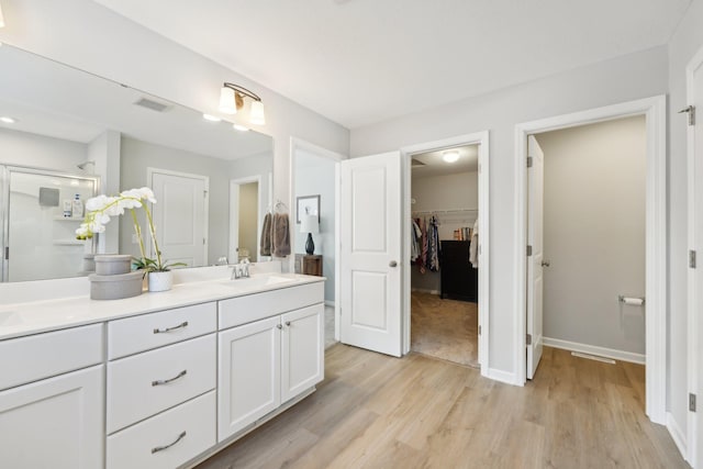 bathroom with vanity, hardwood / wood-style floors, and an enclosed shower