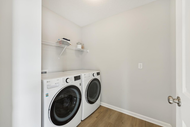 laundry area with hardwood / wood-style floors and independent washer and dryer