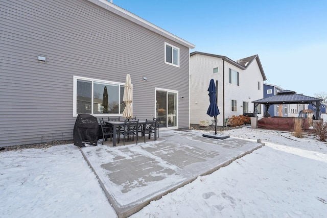 snow covered rear of property featuring a gazebo