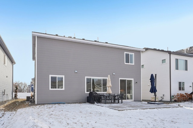 snow covered property with central AC unit