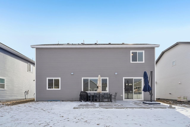 view of snow covered rear of property