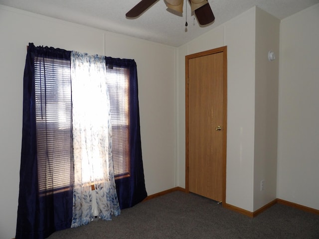 carpeted empty room featuring ceiling fan and vaulted ceiling