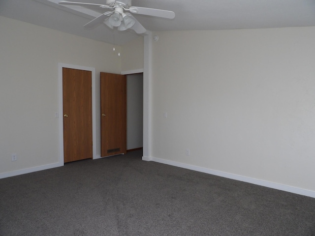 empty room with ceiling fan and dark carpet