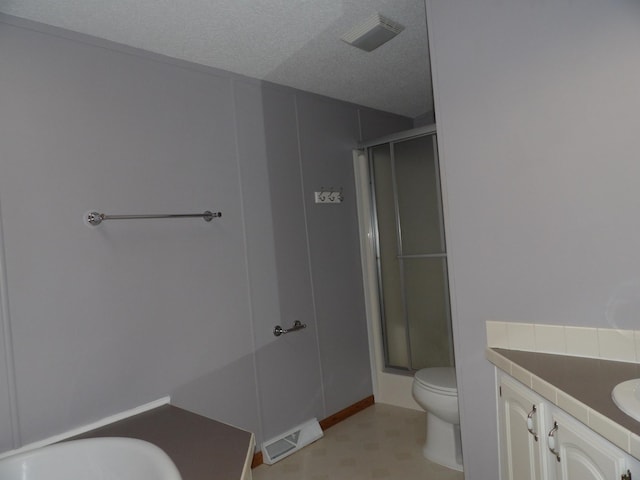 bathroom with a shower with door, a textured ceiling, toilet, and vanity