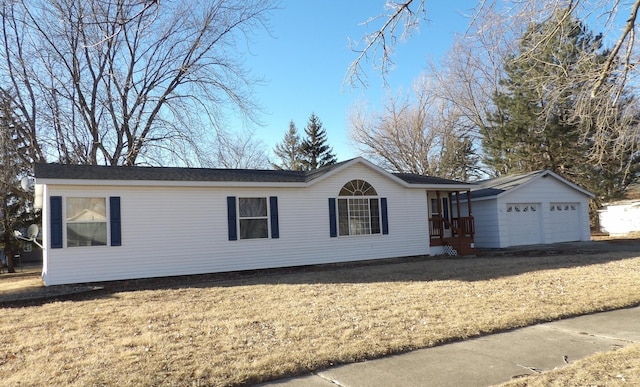 view of front of house featuring a front yard, an outbuilding, and a garage