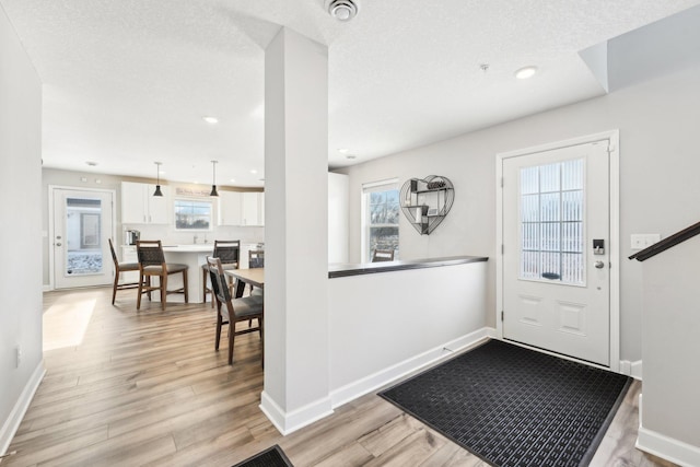 entryway with a textured ceiling and light wood-type flooring