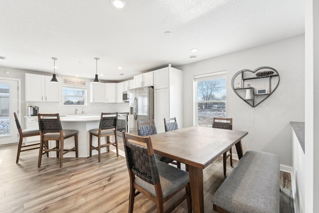 dining room featuring a textured ceiling and light hardwood / wood-style floors