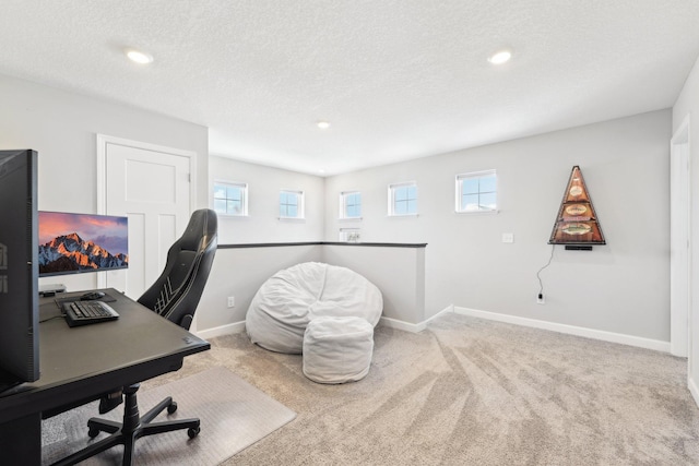 office with light colored carpet and a textured ceiling