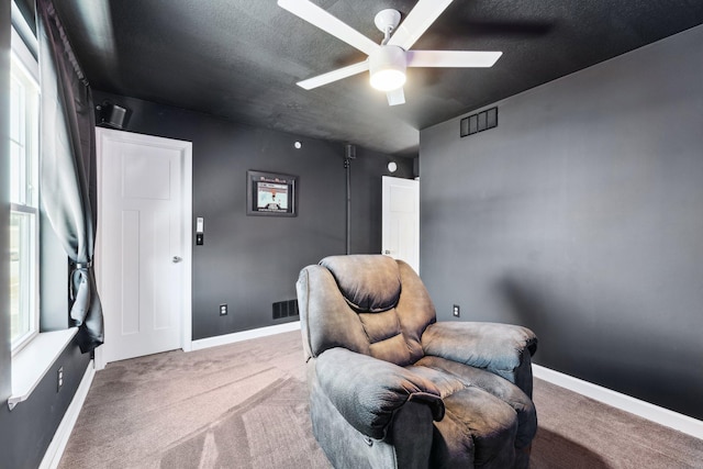 sitting room with ceiling fan, a healthy amount of sunlight, and carpet