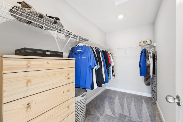 walk in closet with dark carpet