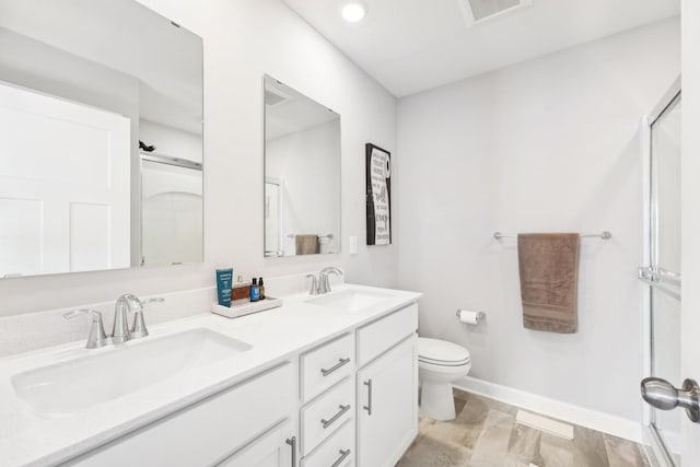 bathroom with a shower with door, vanity, and toilet