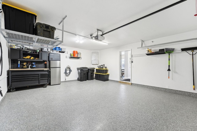 garage with a garage door opener and stainless steel refrigerator