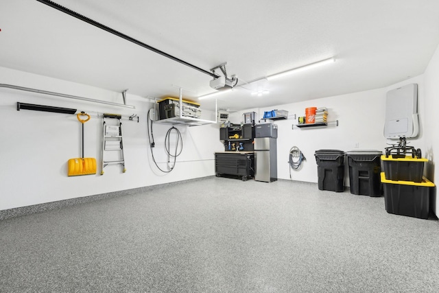 garage featuring stainless steel refrigerator and a garage door opener