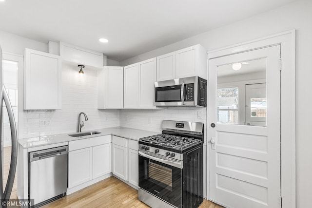 kitchen featuring light hardwood / wood-style floors, sink, white cabinets, and stainless steel appliances