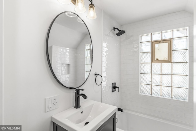 bathroom featuring tiled shower / bath combo and vanity