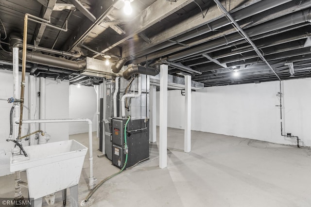 basement featuring heating unit and sink