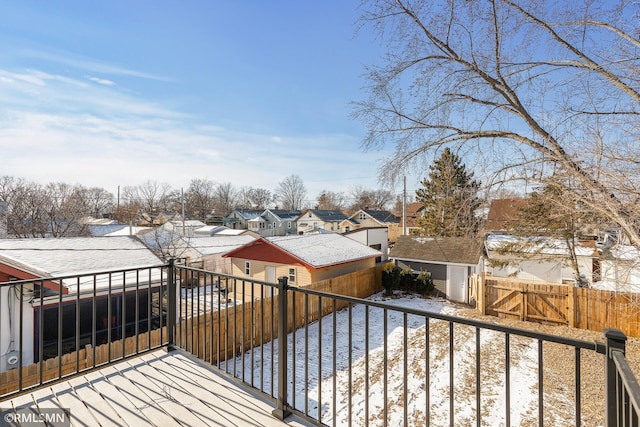 snow covered deck with a water view and a shed