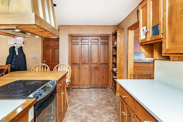 kitchen featuring tasteful backsplash, island range hood, and electric range