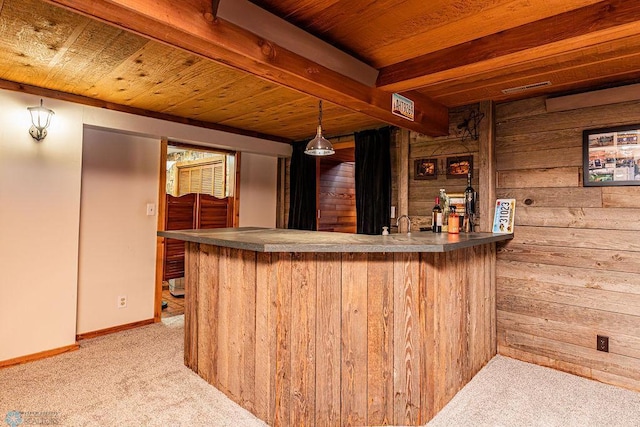 bar featuring wood walls, hanging light fixtures, light carpet, and wooden ceiling