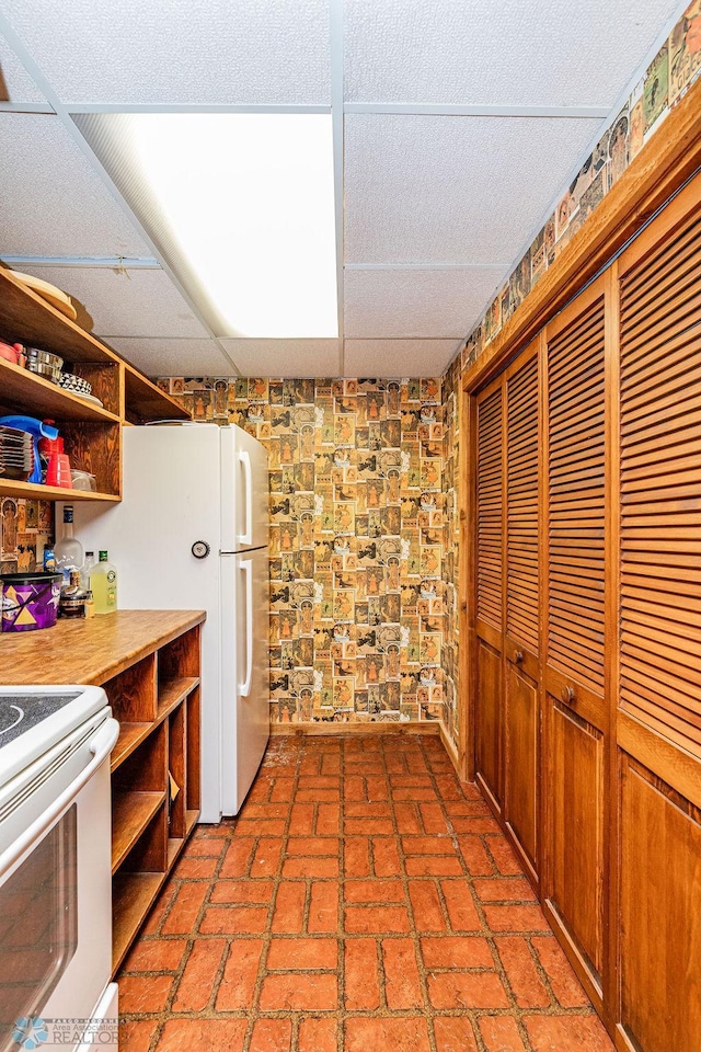 kitchen featuring white appliances and a paneled ceiling