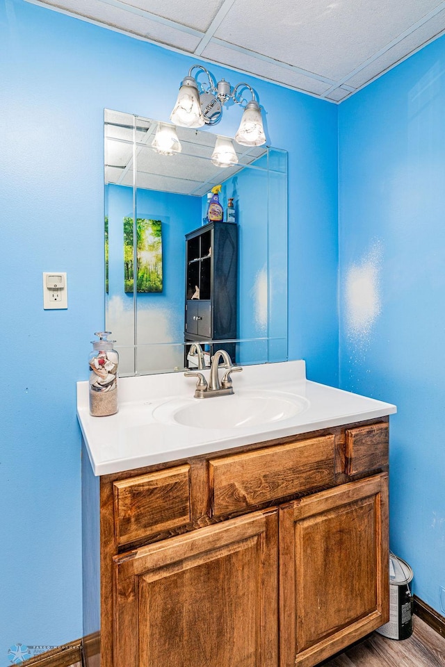 bathroom featuring a paneled ceiling, vanity, and wood-type flooring