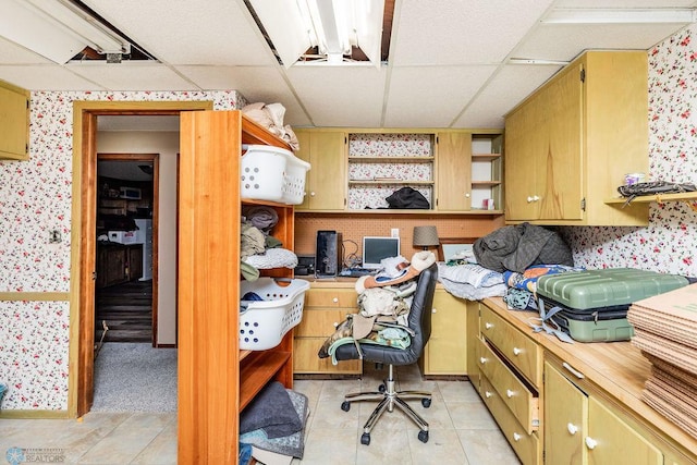 office area featuring a paneled ceiling and built in desk