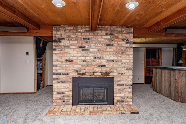 unfurnished living room with beamed ceiling, a fireplace, and carpet