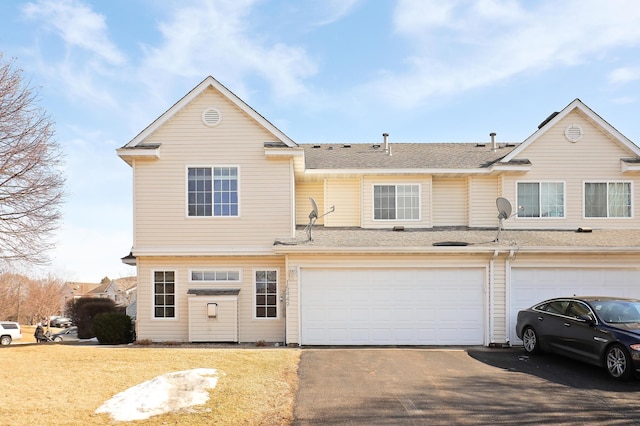 townhome / multi-family property featuring driveway and an attached garage