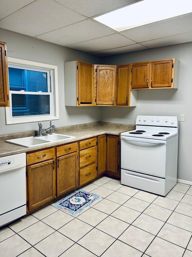 kitchen featuring light tile patterned floors, sink, white appliances, and a paneled ceiling