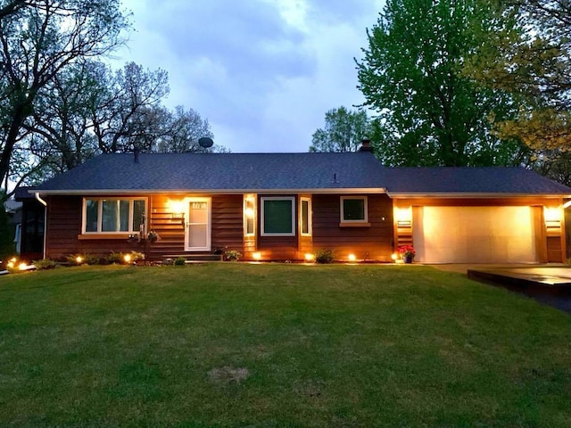 ranch-style house with a garage and a yard