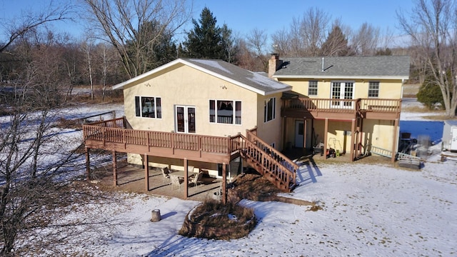 snow covered house featuring a wooden deck