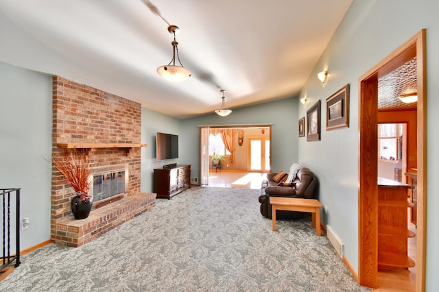 carpeted living room with a fireplace and vaulted ceiling